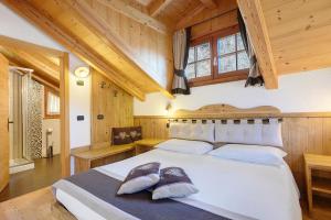 a bedroom with a large white bed with two shoes on it at Mas di Zonadi - intero alloggio in Rabbi