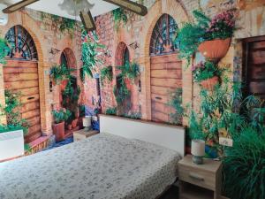 a bedroom with a bed and a brick wall with plants at Villa Abeona in Makarska