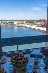 a table with a bowl of food and a view of the water at L'Horizon Bleu - Vue Etang - Parking - Plage à 5 min in Le Barcarès