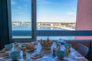 a table with food and a view of the water at L'Horizon Bleu - Vue Etang - Parking - Plage à 5 min in Le Barcarès