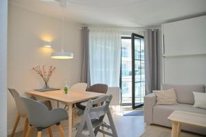 a dining room and living room with a table and chairs at Haus Titania App 9 inkl WLAN in Grömitz