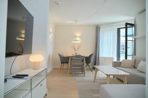 a living room with a couch and a table at Haus Titania App 9 inkl WLAN in Grömitz