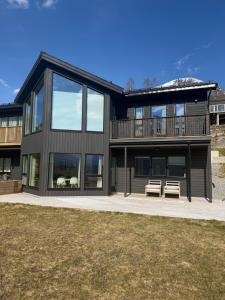 a large black house with a deck at Mountain View apartment in Isfjorden