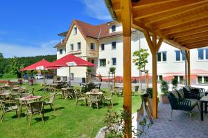 a patio with tables and chairs in front of a building at Familienhotel "Rhön Feeling" in Bernshausen