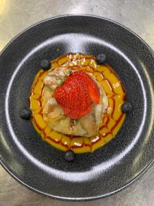 a plate with a dessert with a strawberry on it at Chez Gilles Hôtel Restaurant SA in La Chaux-de-Fonds +25 photos
