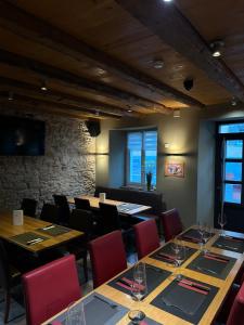 a restaurant with tables and chairs and a stone wall at Chez Gilles Hôtel Restaurant SA in La Chaux-de-Fonds