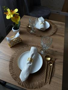 a table with plates and silverware on a wooden table at AIDANA гостиница in Oral