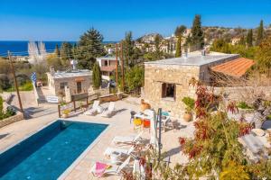 a villa with a swimming pool and a house at Casale Xenia in Lyso