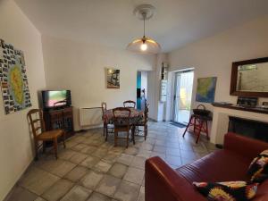 a living room with a table and a tv at Chez Paulette - meublé de tourisme classé 3 étoiles in Zonza