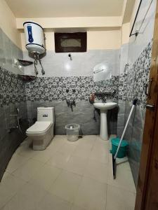 a bathroom with a toilet and a sink at Grham Hostel & Cafe Kasol, Katagla in Kasol