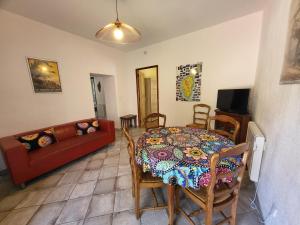 a living room with a table and a couch at Chez Paulette - meublé de tourisme classé 3 étoiles in Zonza