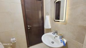 a bathroom with a sink and a shower with a mirror at #302 brand new two large bedrooms in Rujm ash Sharāʼirah +20 photos