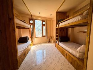 a room with two bunk beds and a window at Grham Hostel & Cafe Kasol, Katagla in Kasol