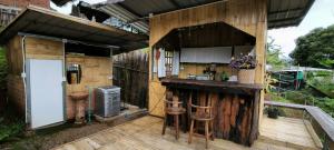 an outdoor kitchen with two stools on a deck at ตั้วบ้านดิน Tuabaandin in Ban Thung Phan Ha