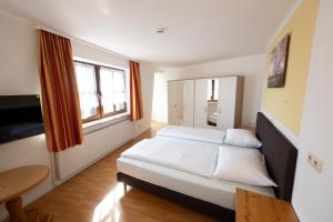 a bedroom with two beds and a table at Gästehaus Willanzheim in Willanzheim +10 photos