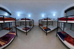 a room with four bunk beds in it at The rest point dormitory in Khātu