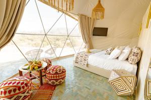 a bedroom with a bed and a large window at Ksar Shama - Atlas Mountain Retreat in Ouirgane