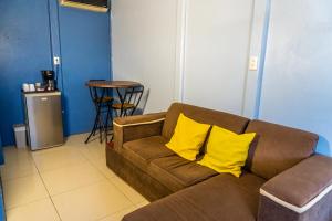 a living room with a brown couch with yellow pillows at Cabinas Arenal Home in Tanque