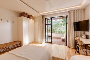 a bedroom with a bed and a table and a television at Barrington's in Plettenberg Bay +51 photos