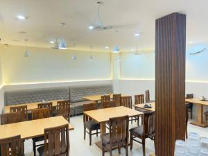 a dining room with wooden tables and chairs at Shri Radha Krishnam in Barsāna