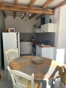 a kitchen with a wooden table and chairs in a kitchen at LAVAUR Location de meublé saissonier in Labastide-Saint-Georges