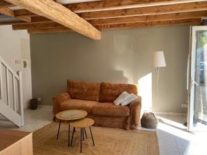 a living room with a couch and a table at LAVAUR Location de meublé saissonier in Labastide-Saint-Georges