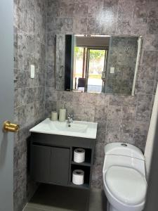 a bathroom with a sink and a toilet and a mirror at Hermosa casa en Talca in Talca +18 photos
