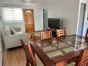 a living room with a glass table and a television at Hermosa casa en Talca in Talca