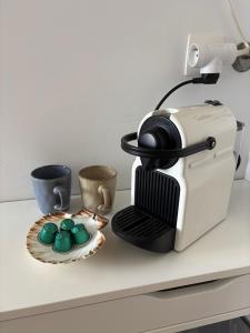 a toaster sitting on a counter next to a plate of cupcakes at De Strandloper B&B Oostduinkerke in Koksijde