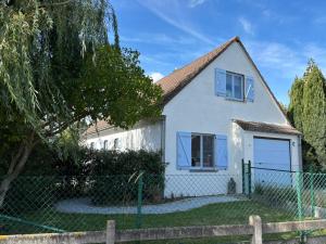 a white house with blue windows and a fence at De Strandloper B&B Oostduinkerke in Koksijde