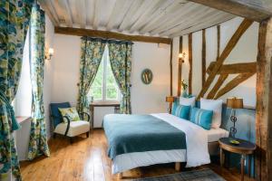 a bedroom with a blue and white bed and a chair at Maison le Village - Maison d’Hôtes in Montagny-lès-Beaune +143 photos