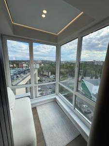 a room with large windows with a view of a city at RentNow Apartments Luxury Apartment with Balcony and Parking in Chişinău