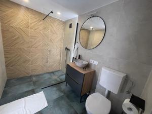 a bathroom with a sink and a toilet and a mirror at Pillanat Wellness Kabin in Bánk