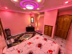 a bedroom with a bed with red flowers on it at Iqama Al-Nakhlah in Ghardaïa