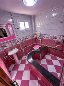 a pink and white bathroom with a tub and a sink at Iqama Al-Nakhlah in Ghardaïa +5 photos