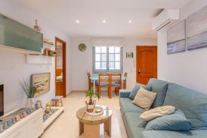 a living room with a blue couch and a table at Apartament Sant Antoni de Calonge in Sant Antoni de Calonge