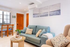 a living room with a blue couch and a table at Apartament Sant Antoni de Calonge in Sant Antoni de Calonge