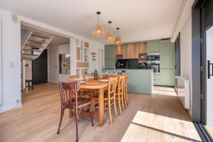 a kitchen and dining room with a wooden table and chairs at Maison Desmathi in Saint-Pierre-Quiberon