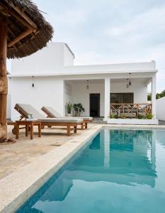 a villa with a swimming pool and a house at Daystar Villa in Watamu