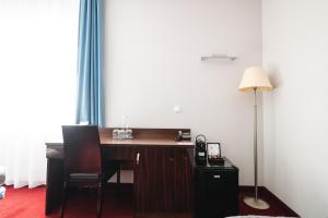 a desk with a lamp and a telephone in a room at Focus Hotel Gdańsk in Gdańsk +36 photos