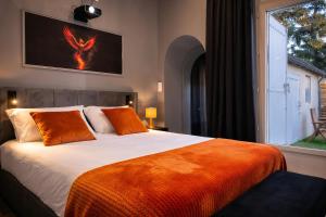 a bedroom with a large bed and a window at Suite Phoenix - Maison Cosy avec Terrasse & Cinéma Privé in Angoulême