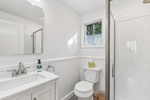 a bathroom with a toilet and a sink and a shower at Steps to Beach + Sunset Views! East Marion Home in East Marion +28 photos