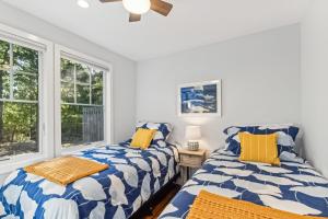 two beds in a room with two windows at Steps to Beach + Sunset Views! East Marion Home in East Marion