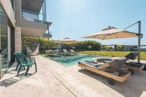 a backyard with a pool with a bed and an umbrella at Bright villa w pool & outdoor grill u303 in Barú +47 photos