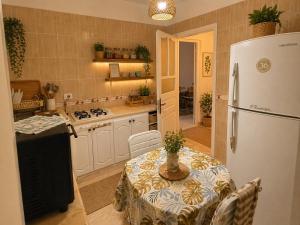 a kitchen with a table and a white refrigerator at شمس in Hammamet Nord