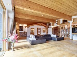 a large living room with a leather couch and wooden ceilings at Jagd Chalet in Leutasch