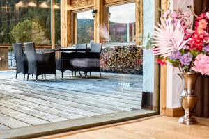 a piano on a deck with chairs and flowers at Jagd Chalet in Leutasch