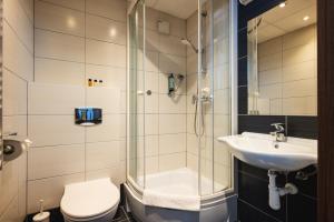 a bathroom with a shower and a toilet and a sink at Focus Hotel Gdańsk in Gdańsk