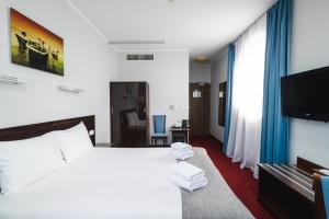 a hotel room with a bed and a flat screen tv at Focus Hotel Gdańsk in Gdańsk