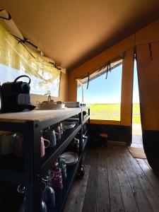 a kitchen in a tent with a table with pots and pans at Glamping Safaritent 4 persoons in Hindeloopen +19 photos